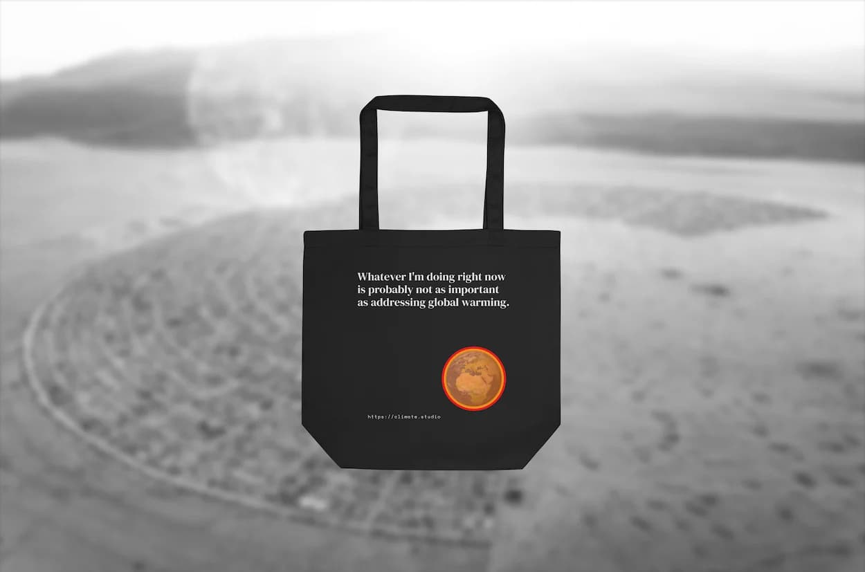 Black tote bag with climate message against Burning Man background