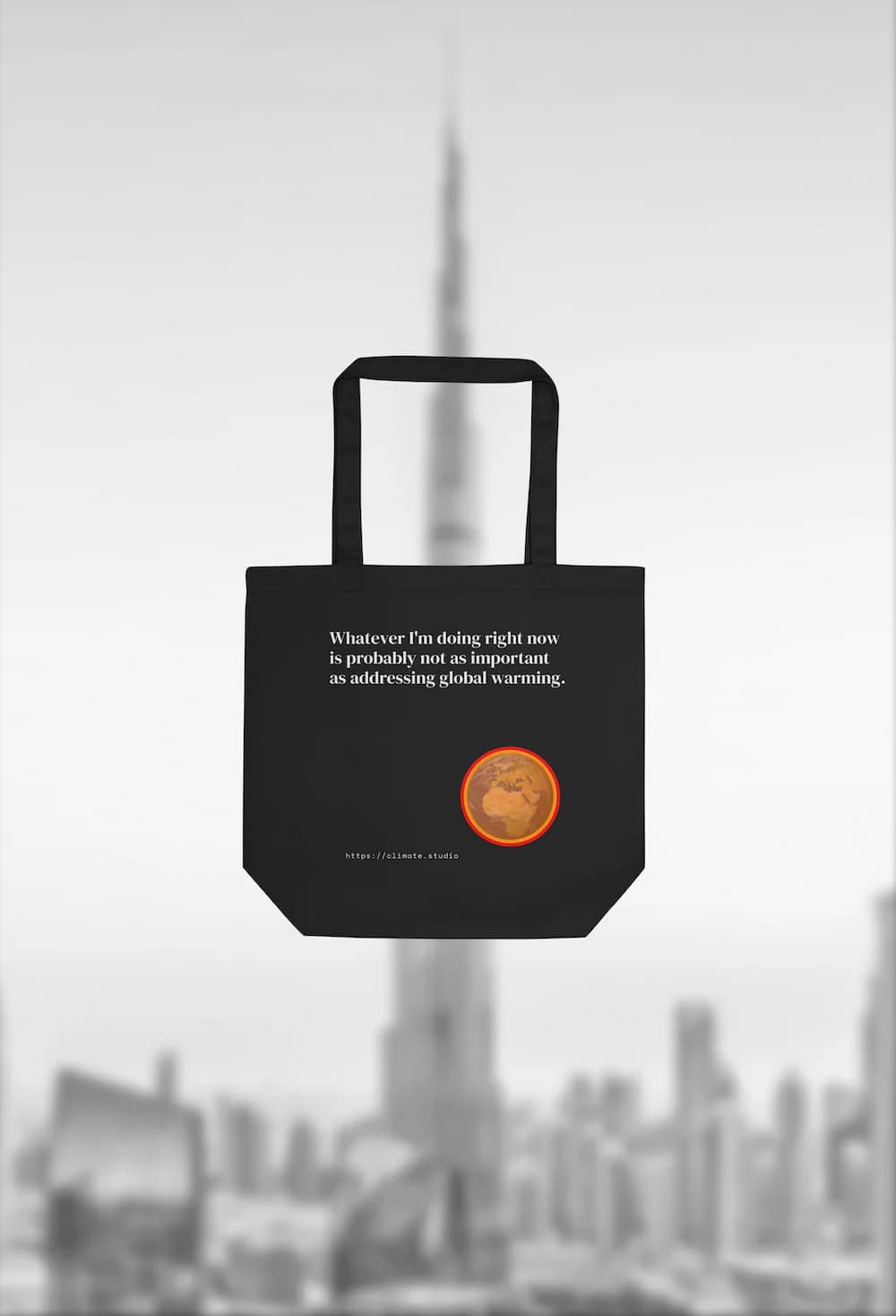 Black tote bag with climate message against Dubai background