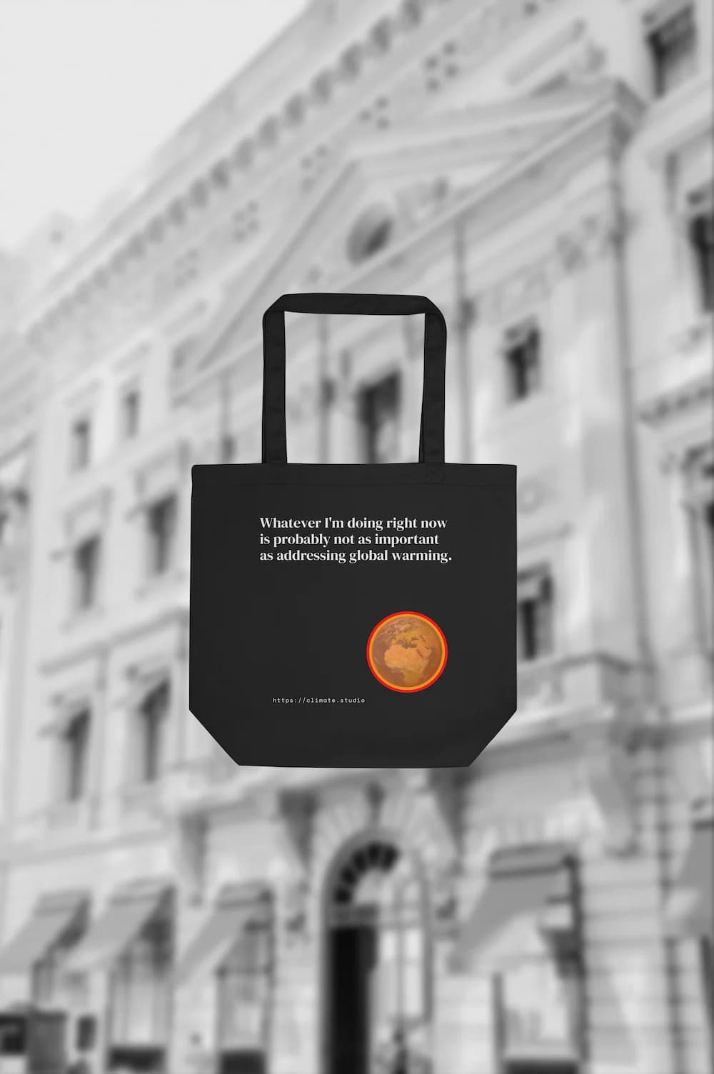 Black tote bag with climate message against fashion house background