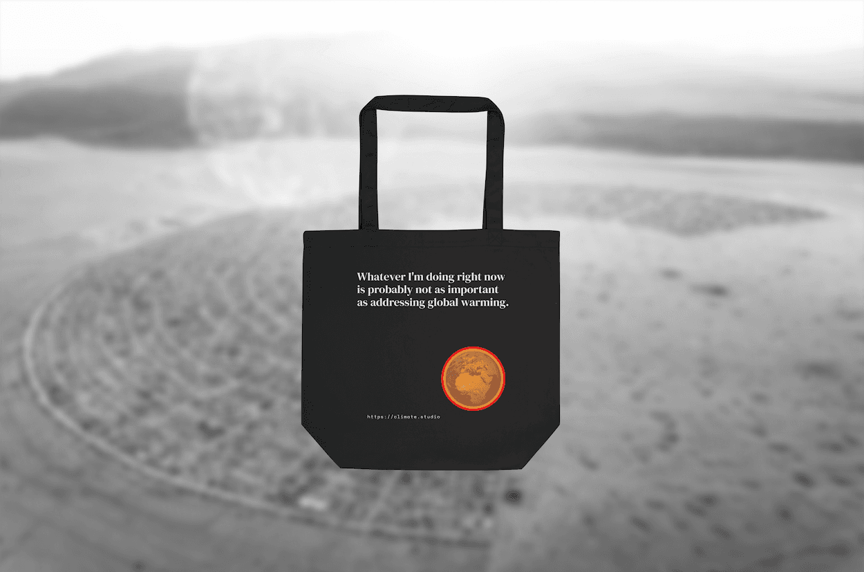 Black tote bag with climate message against Burning Man background